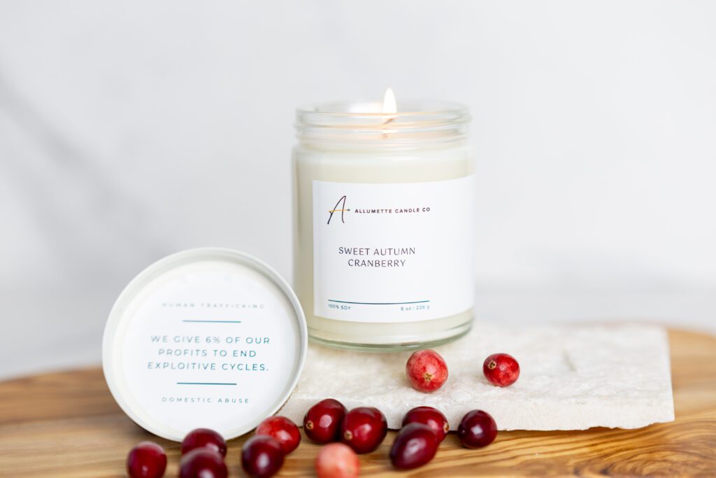 Beautiful cranberry scented candle displayed with real cranberries