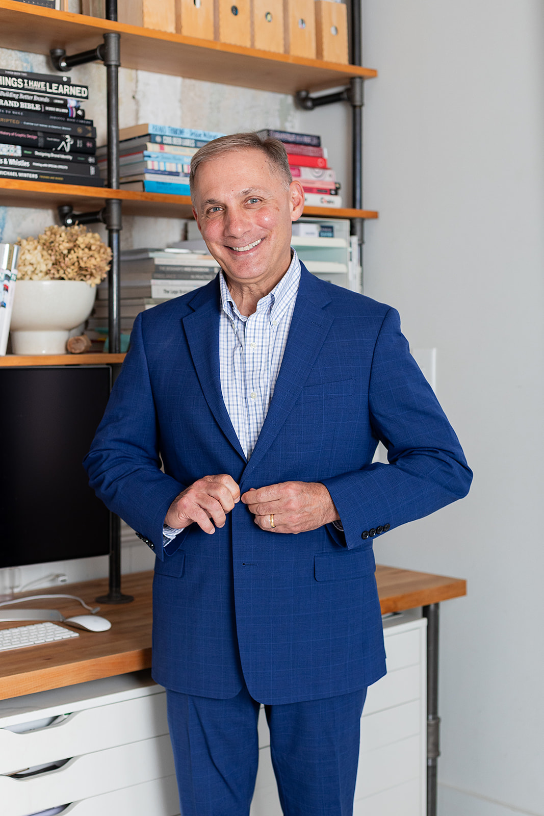 Charlie, Insurance agent posed to button jacket while smiling at the camera. 