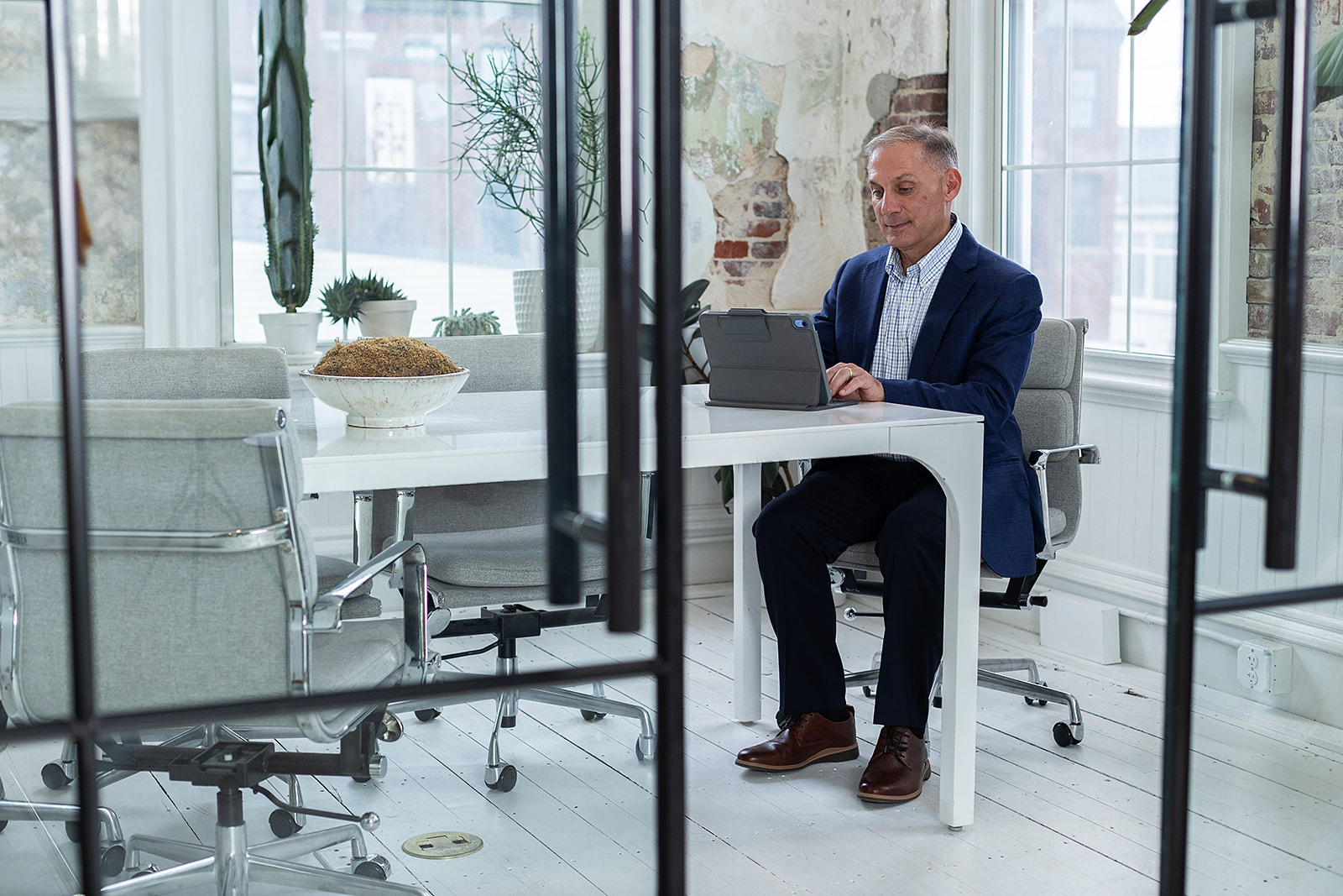 Photo of charlie seated and working at a desk on a tablet. 