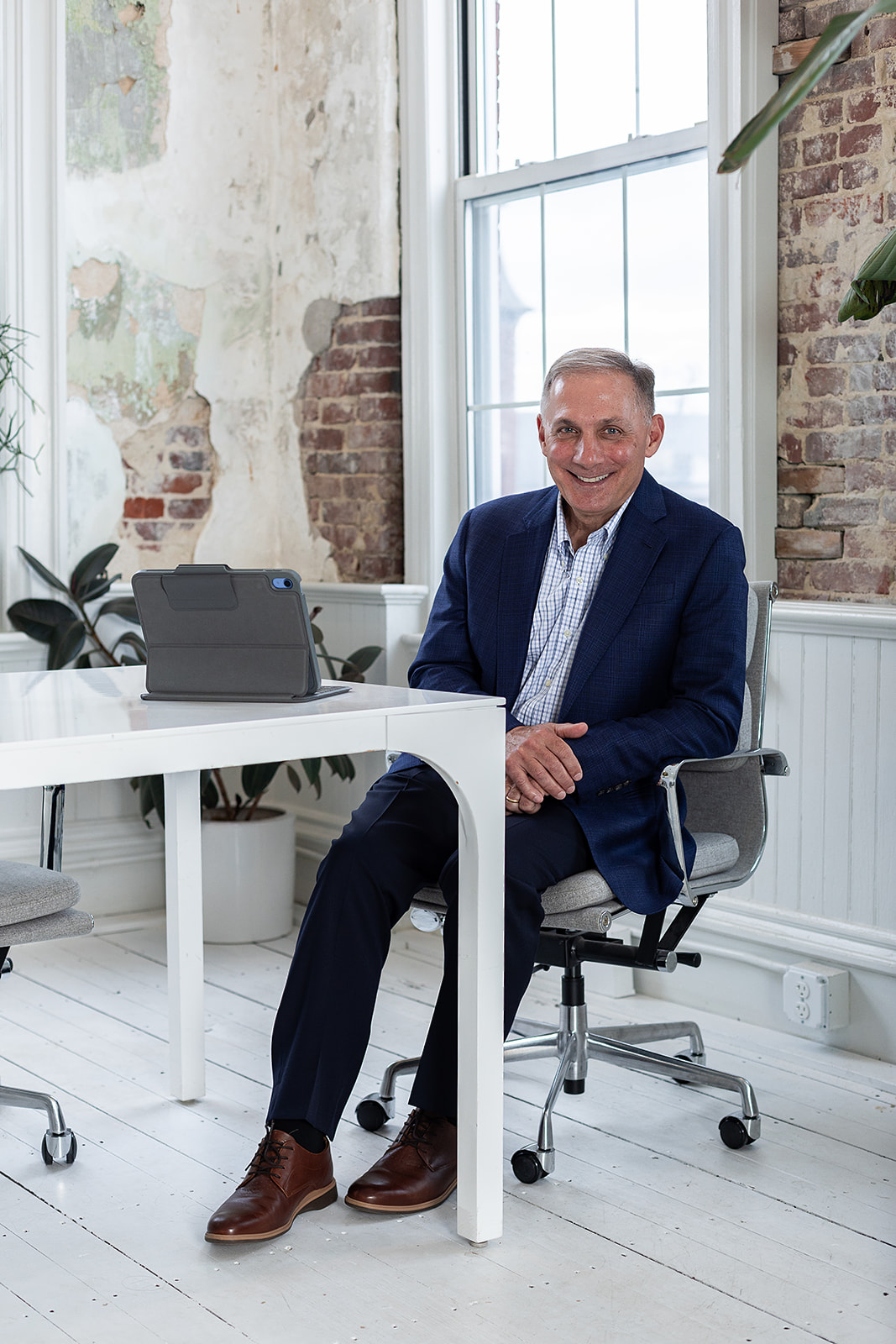 Photo of Charlie sitting at desk, smiling to the camera. 