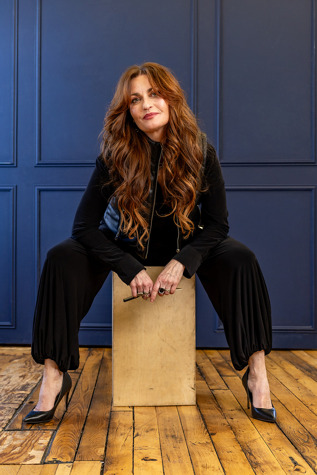 Posed photo of Julianne sitting in front of a blue wall, she is looking at the camera. 