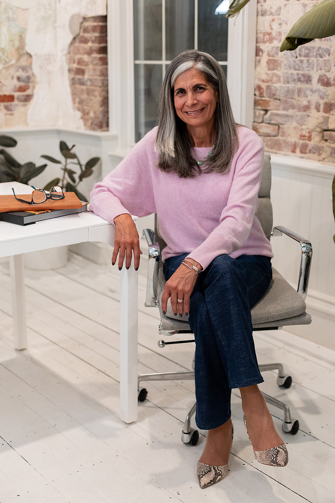 Photo of Mary seated comfortably at a desk, smiling at camera. 