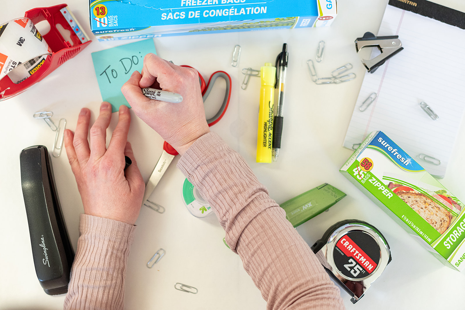 Photo of Shira writing on a post-it note.